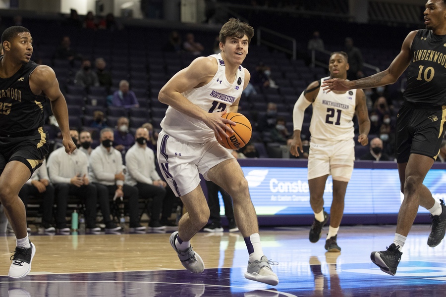 A Northwestern basketball player in a white jersey stares