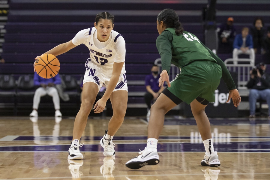 Girl in white jersey with braids in her hair dribbles basketball.