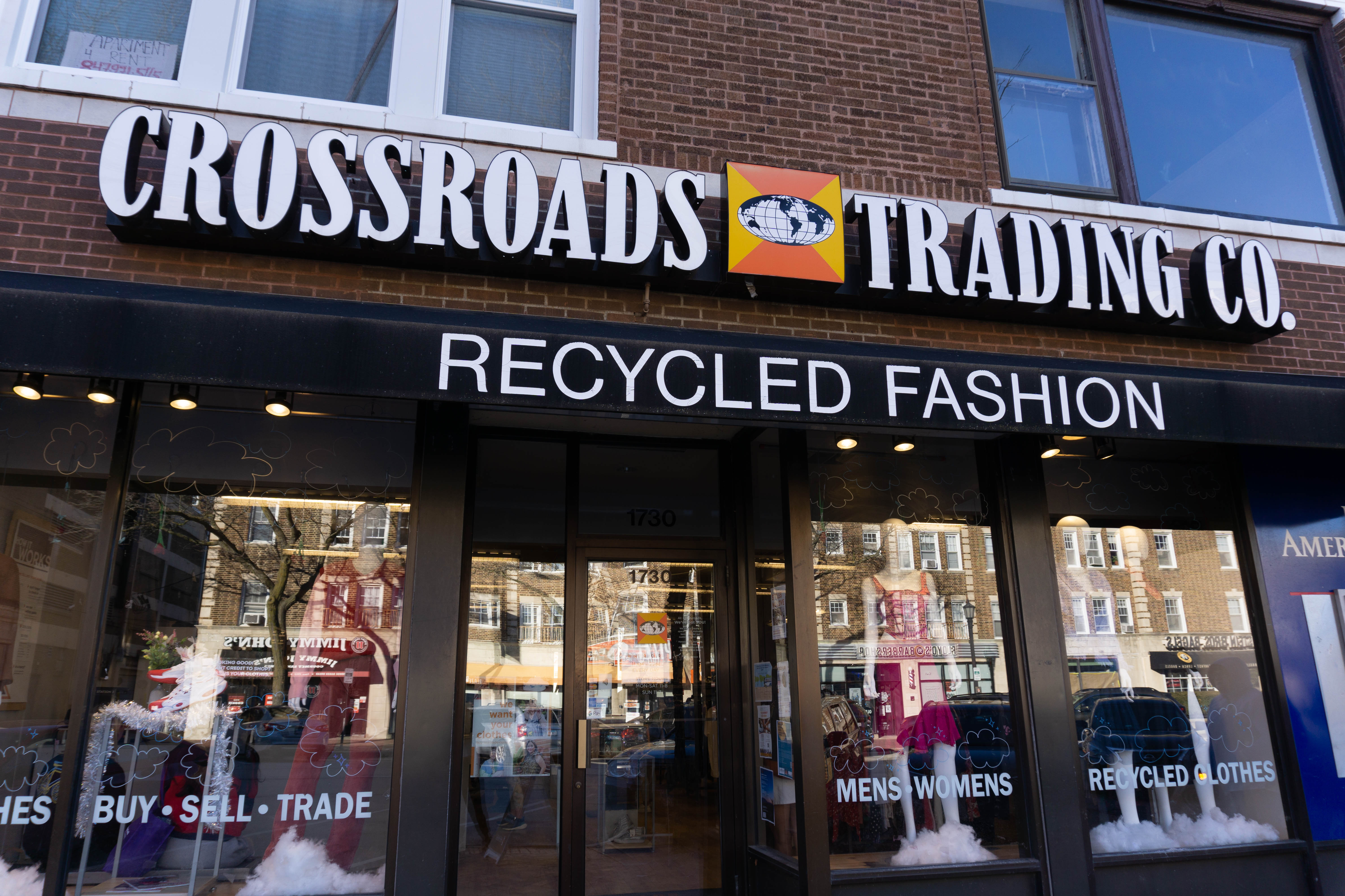 A sign reads “Crossroads” in white letters on a brick building.