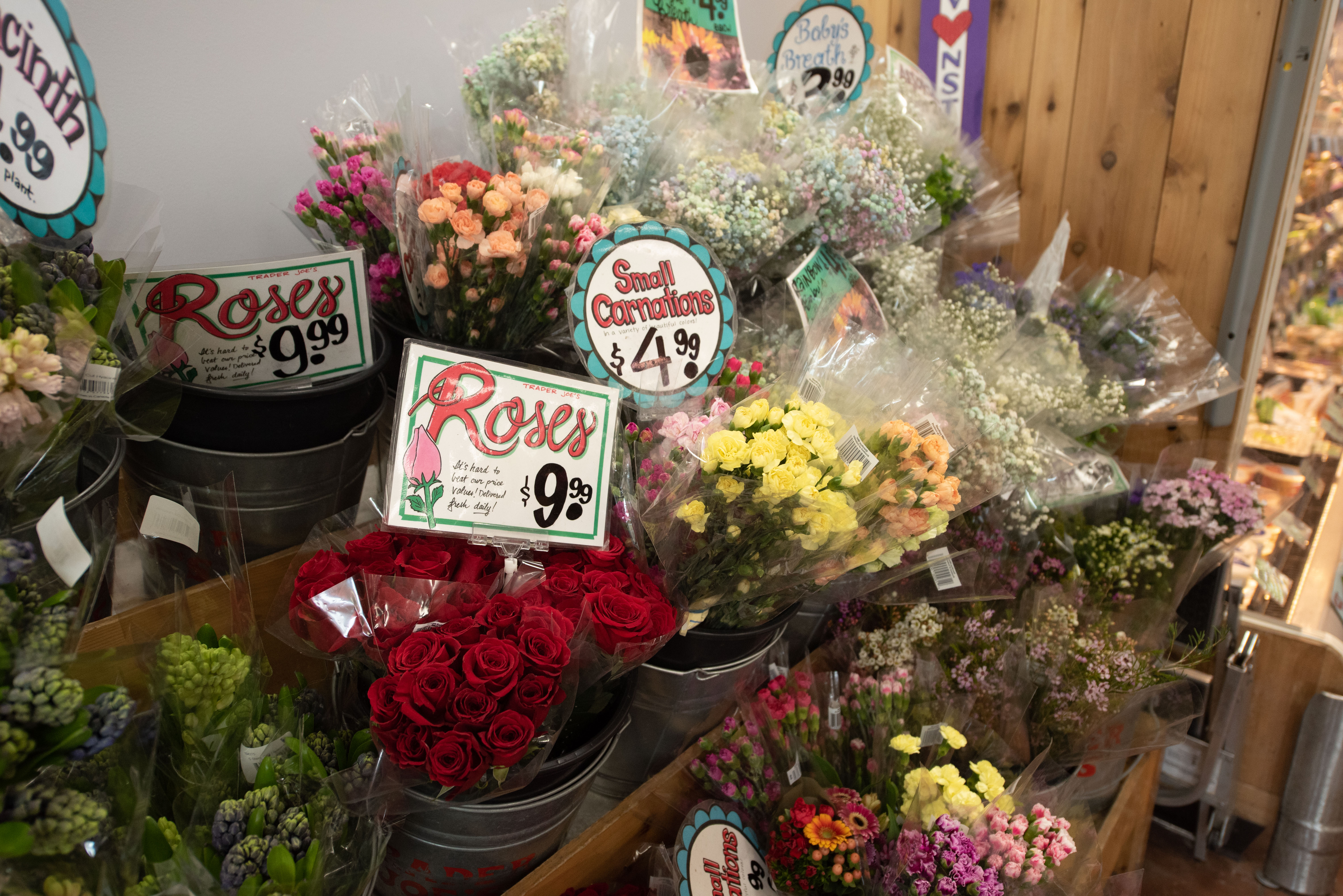 Vases of flowers sit on a shelf.