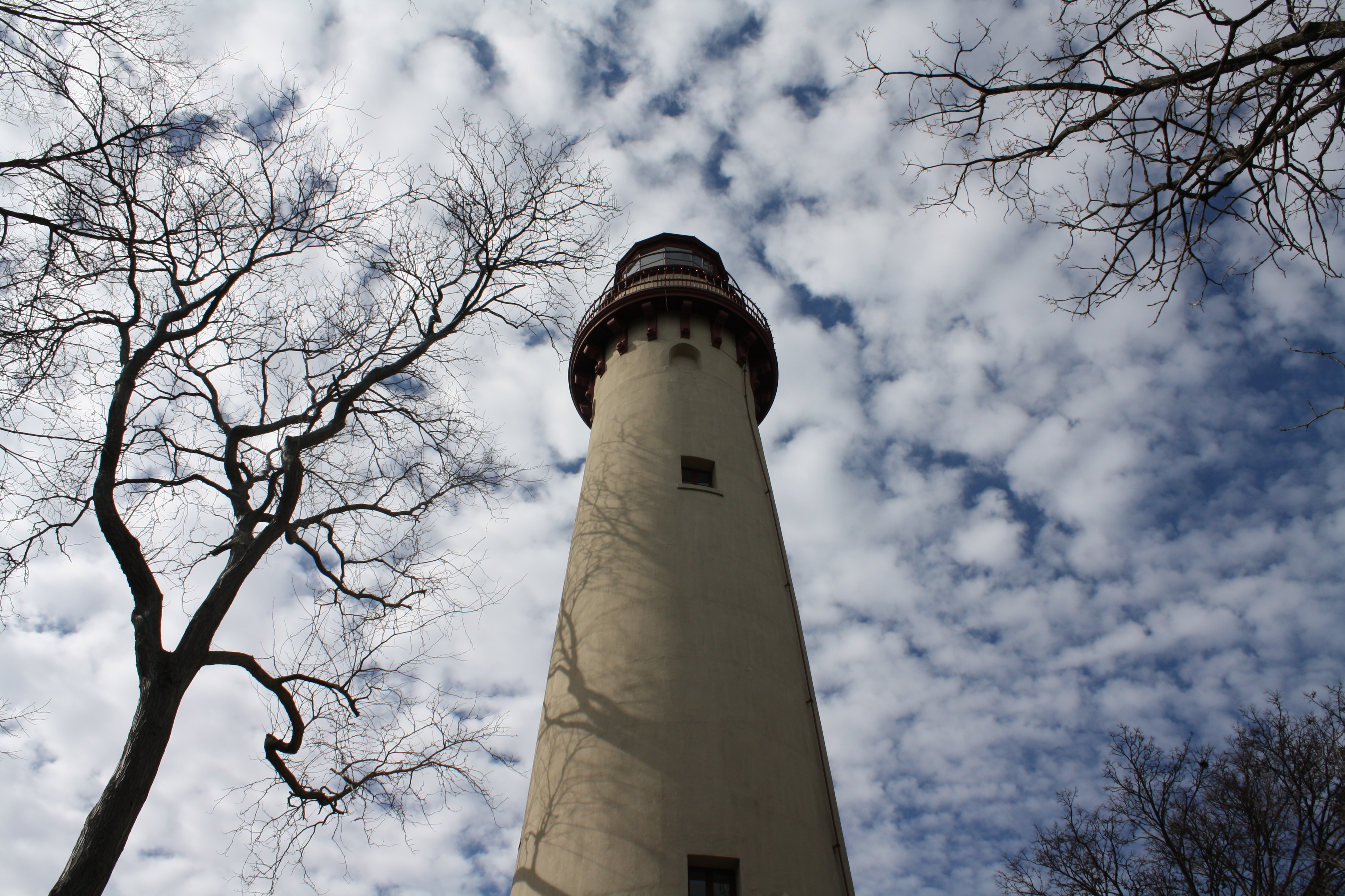 A lighthouse in front of a cloudy sky