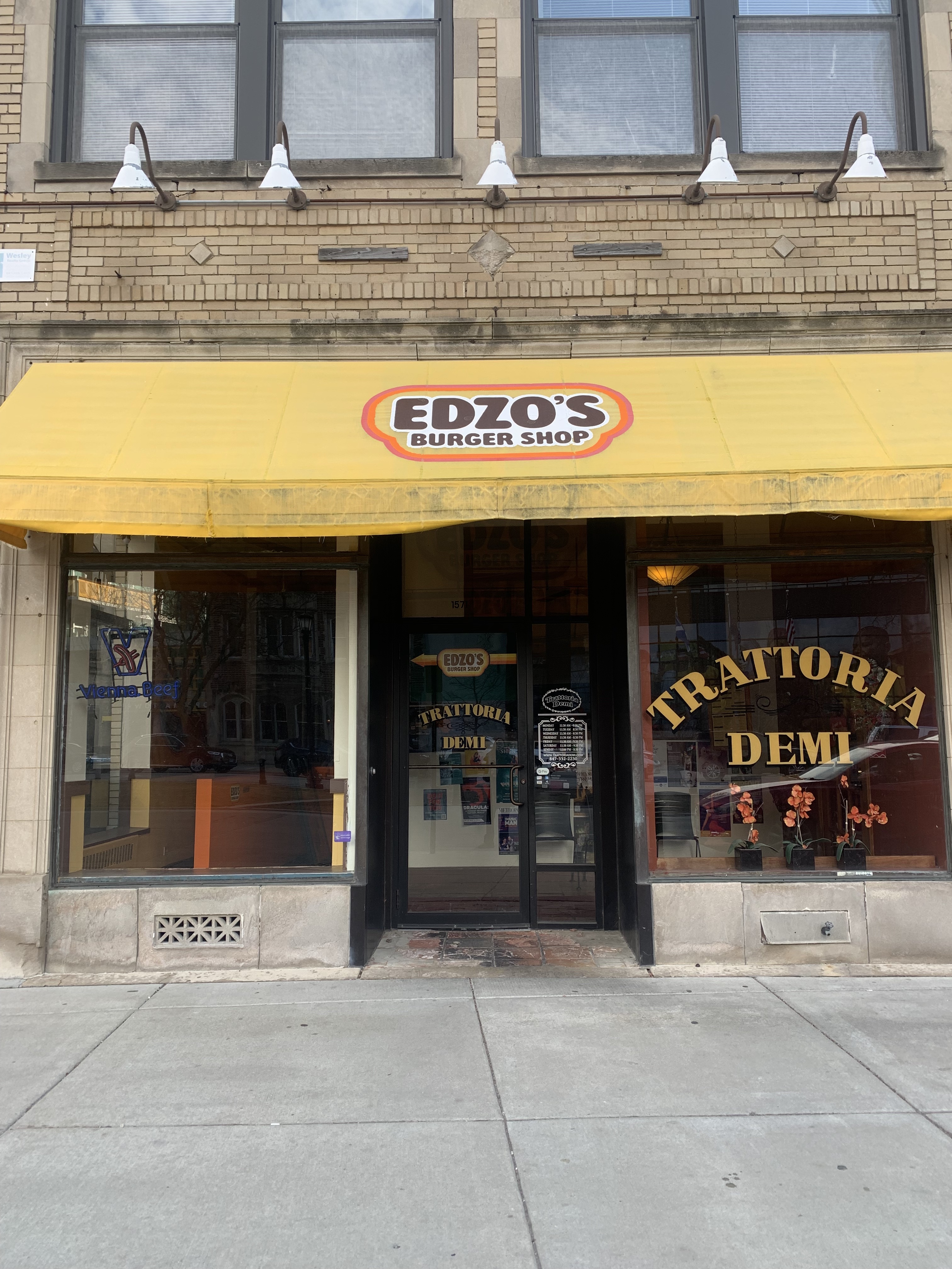 Edzo’s Burger Shop storefront with yellow awning and name of the store in brown letters.