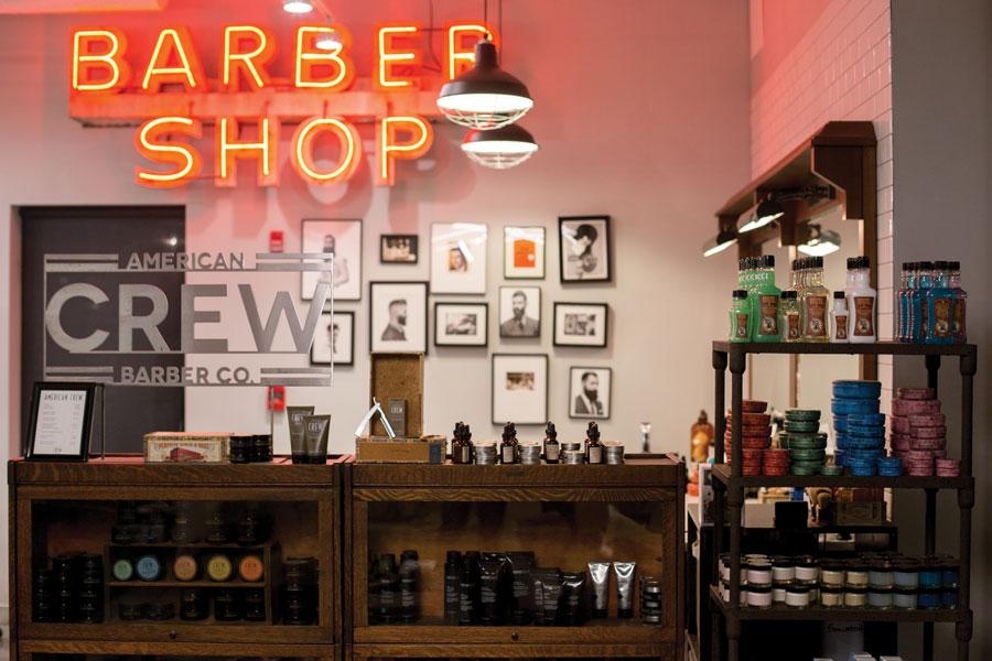 Front of a store that has the words 'BARBER SHOP' in red LED lighting