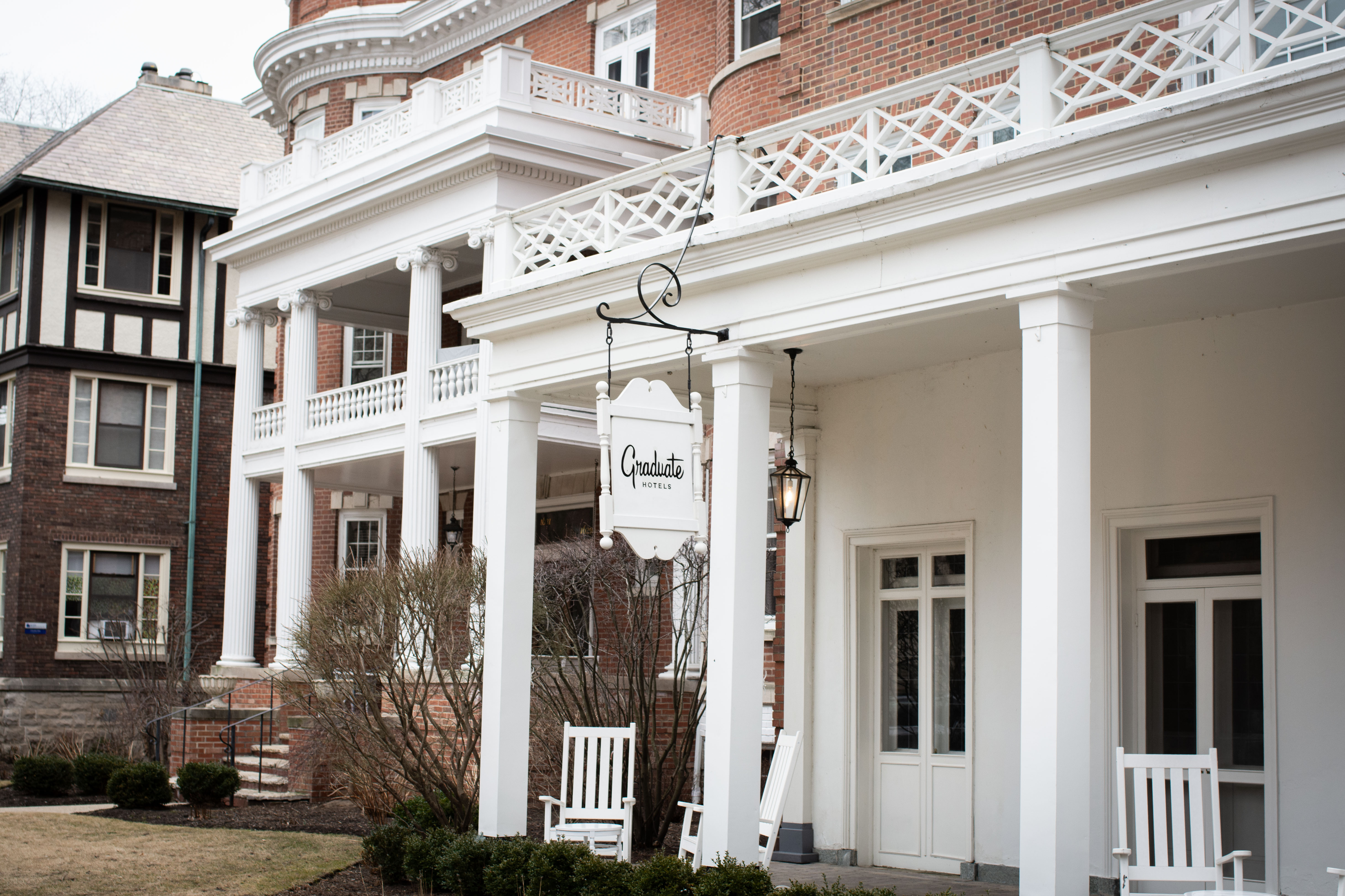 A white building with a sign that says “Graduate Hotels”